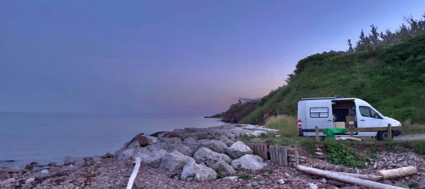 Lonavity van conversion, rental and products, travelling in Quebec, boondocking by the St. Lawrence River, the sunset is beautiful purple and pink, nature is beautiful, love Vanlife