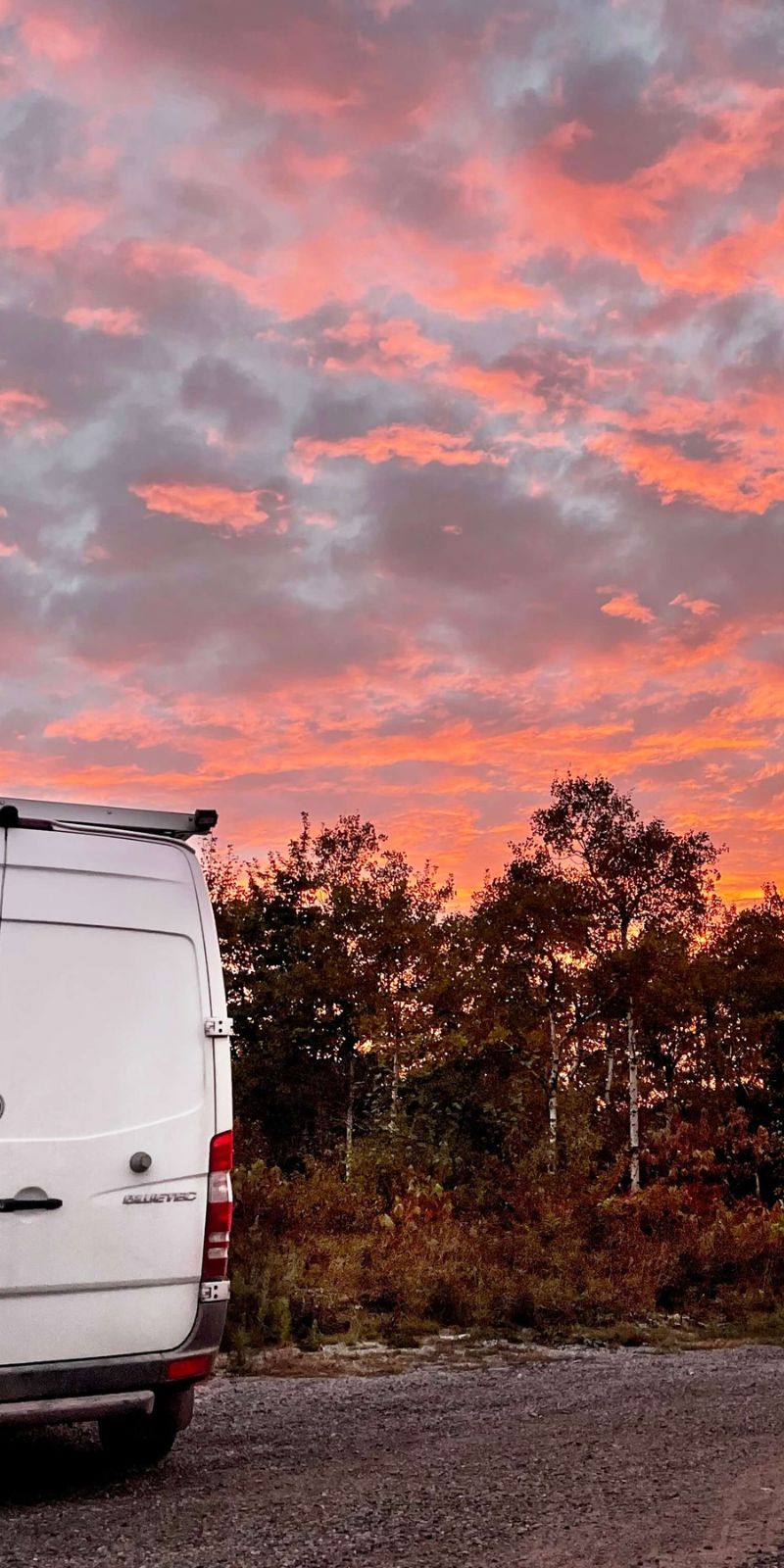 Lonavity Vanlife, Van parked in Ontario Boondocking Spot. The sky is completely red and yellow beautiful sunset